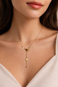 Gold necklace with butterfly pendants on a model wearing a white top